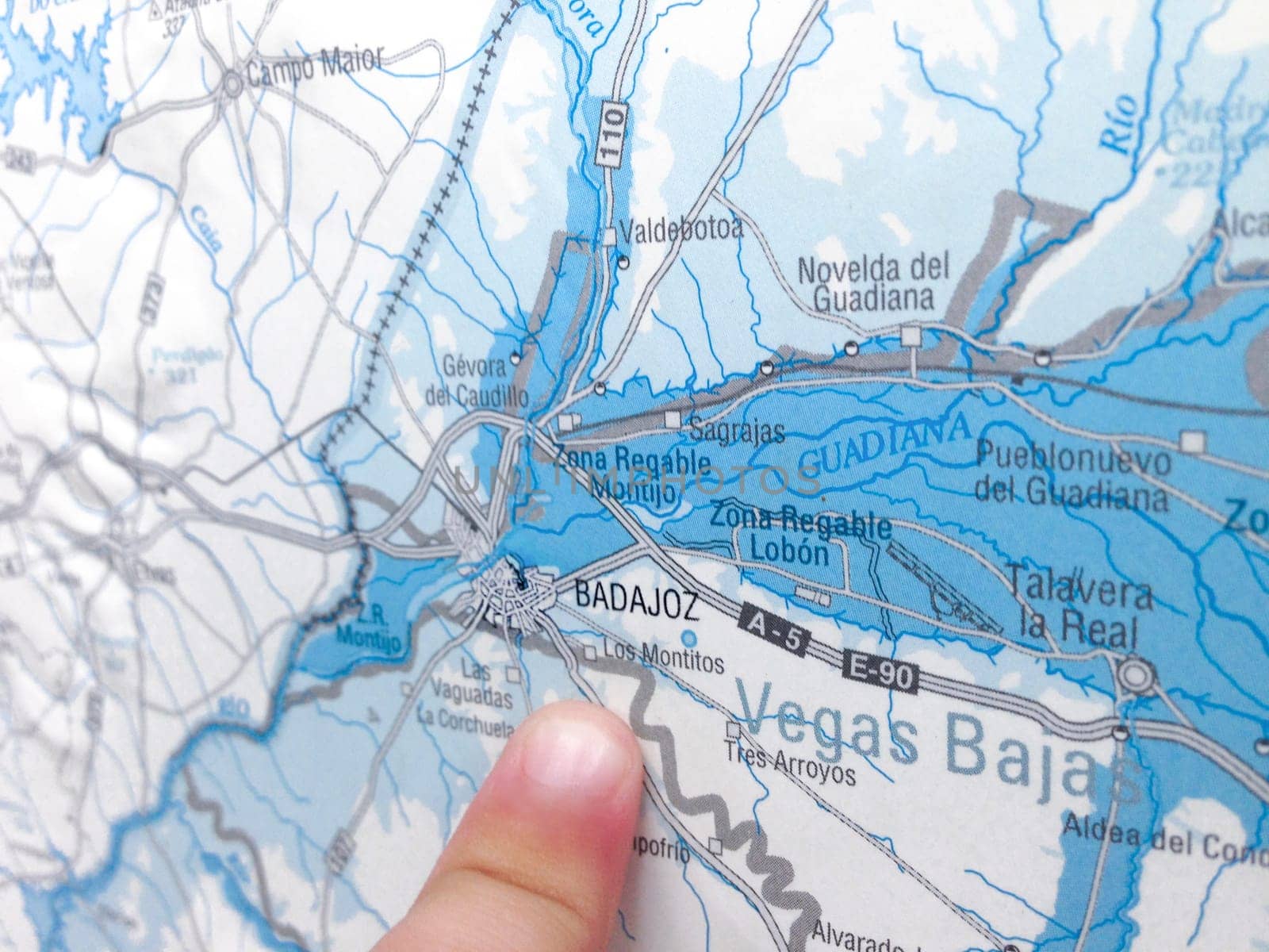 Child finger pointing the city of Badajoz over map. Selective focus
