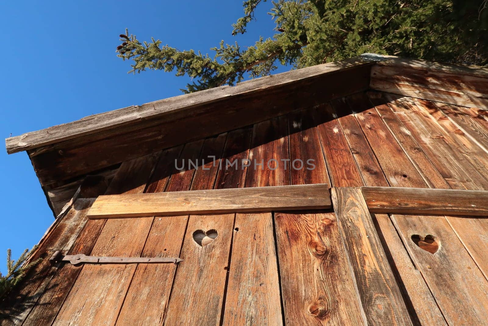 Wooden barn hut shelter shed with heart shaped holes in its doors, Allgau, Germany 2021