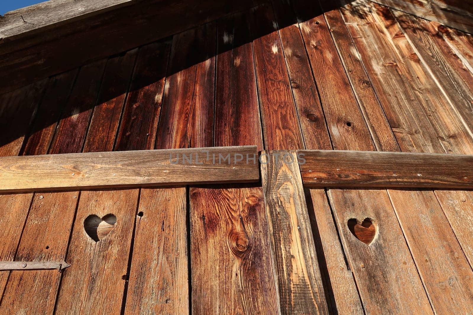 Wooden front of a barn hut shed shelter with heart shaped holes, Allgau, Germany 2021