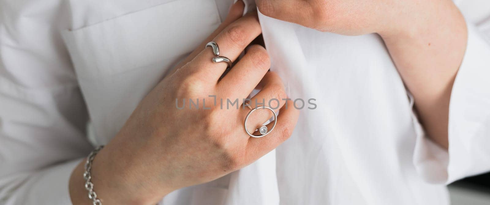 Women Jewelry concept. Woman's hands close up wearing rings and necklace modern accessories elegant lifestyle.