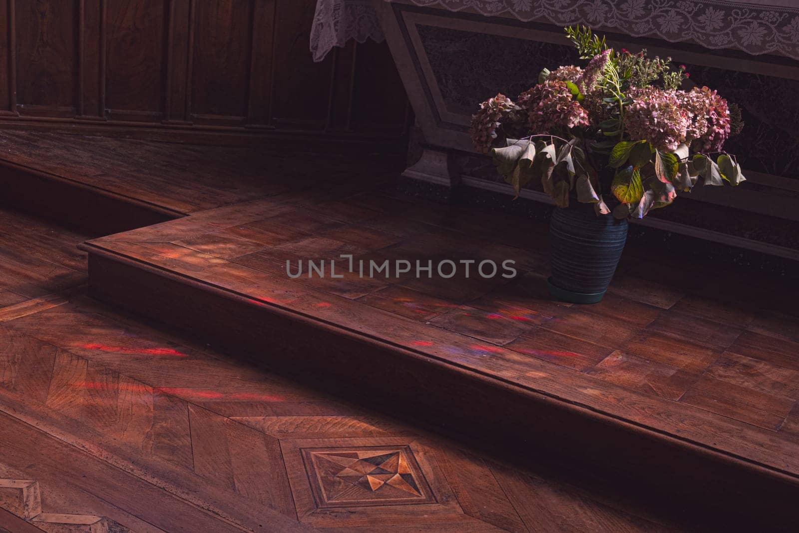Flowers at the foot of the church altar. Dark atmosphere of contemplation. Photography taken in France