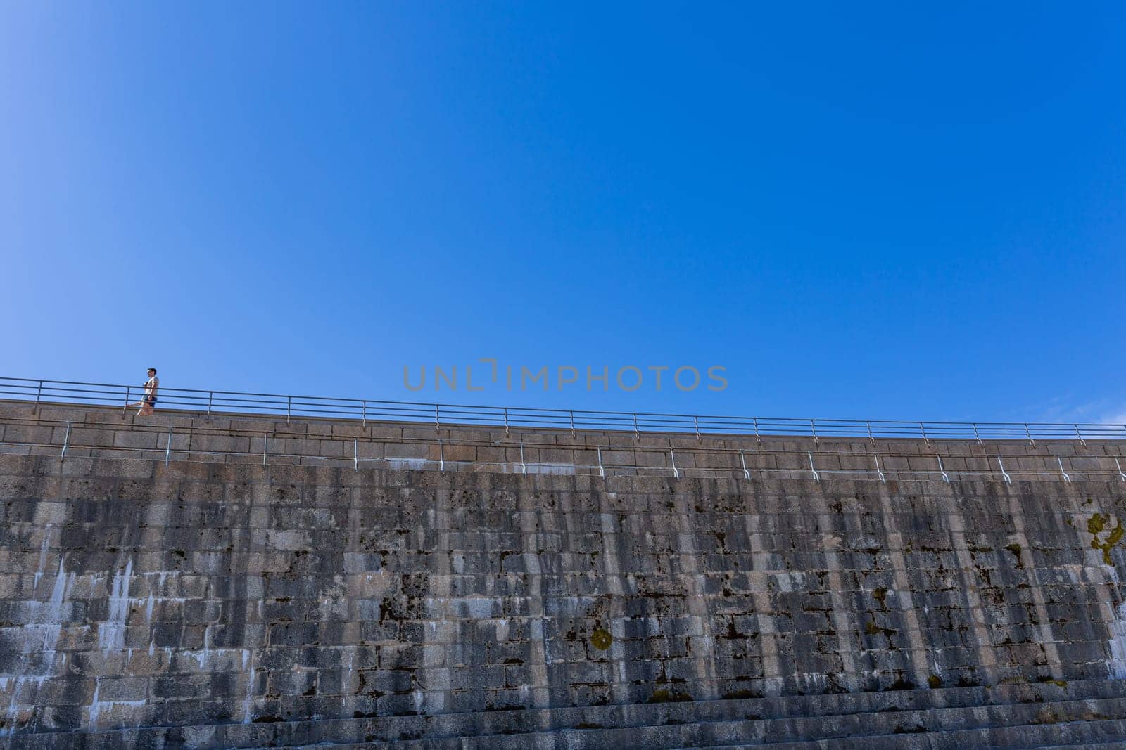 Serra da Estrela, Portugal: 22 August 2023: Couple walking at the dam of Lagoa Comprida, the highest point of Portugal, in Serra da Estrela