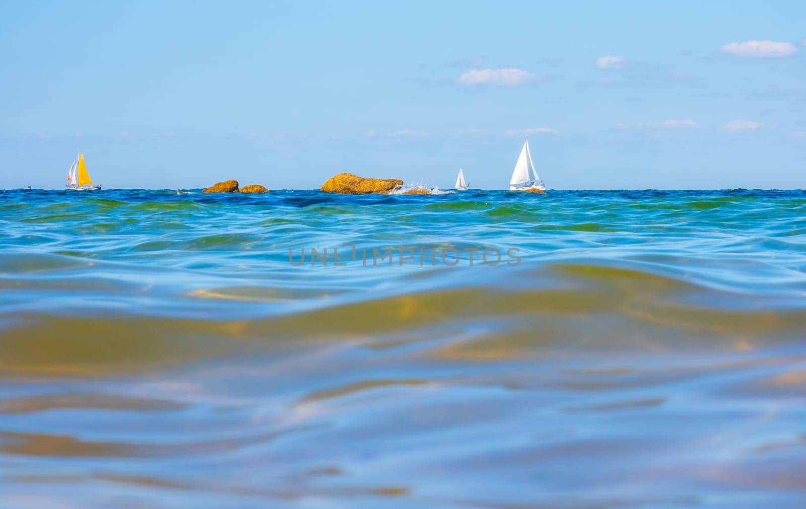 Boats and waves seen by a swimmer at sea level, photography taken in Vendée, France