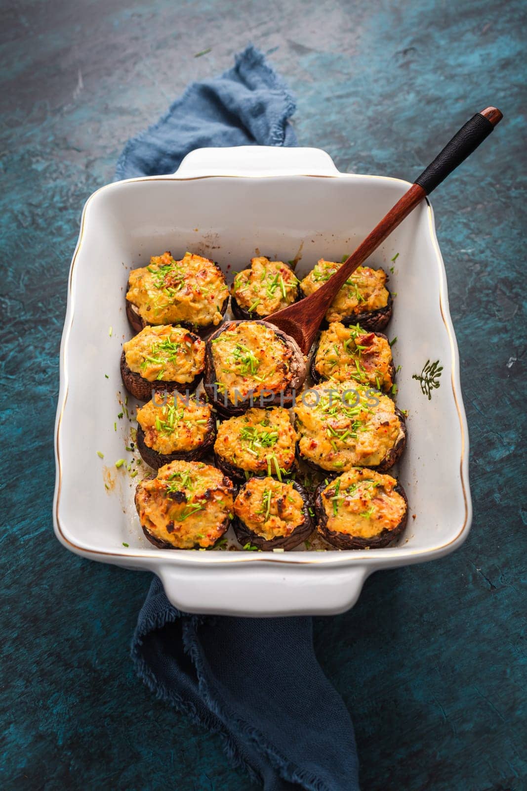 Oven baked stuffed mushrooms - champignons with cream cheese and dried tomatoes in casserole