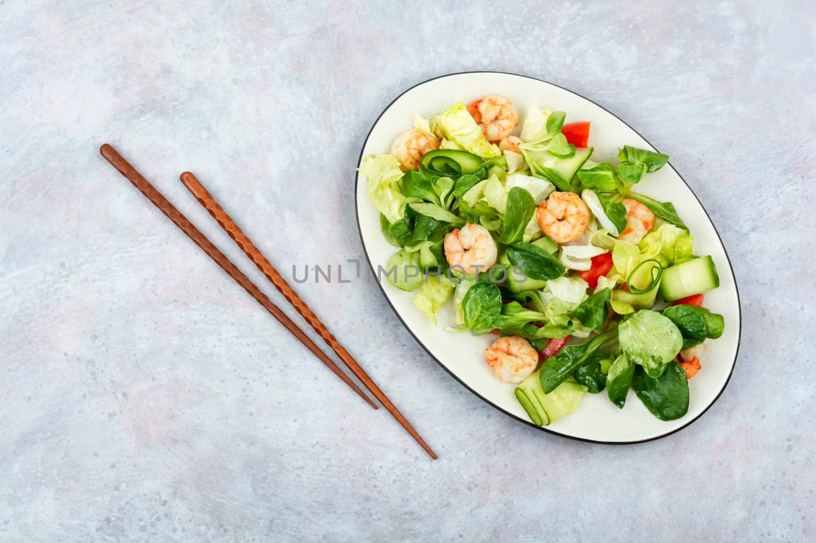 Plate with salad of fresh vegetables, mixed greens and shrimp. Prawns salad. Clean food, top view, copy space.