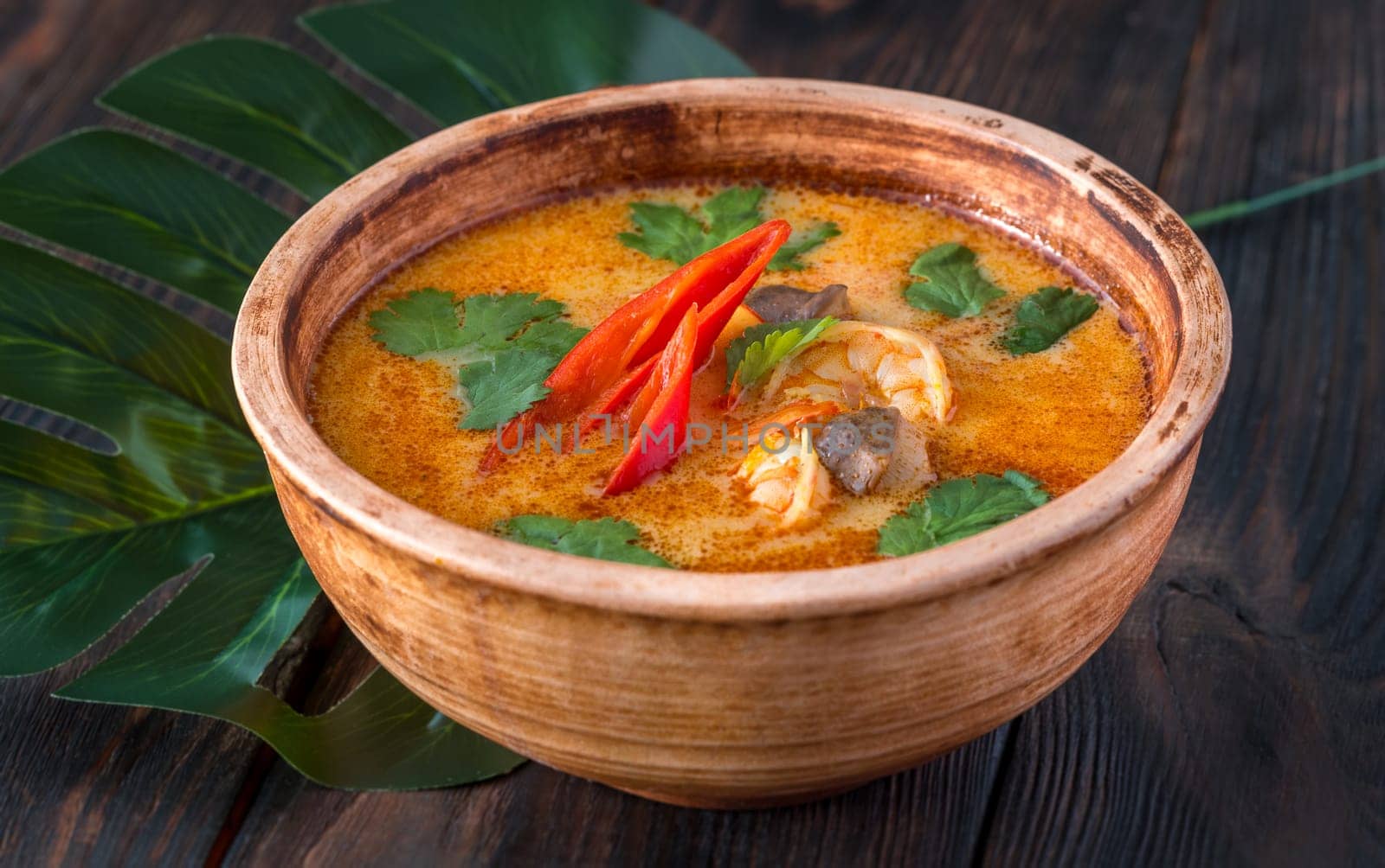 Bowl of tom yum soup on wooden background