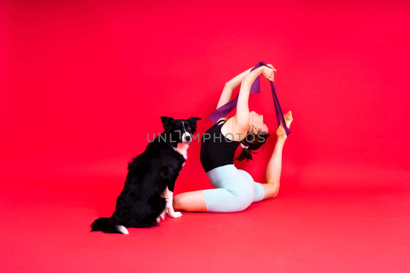 Woman with cute dog border collie is in a studio. Sport with pet