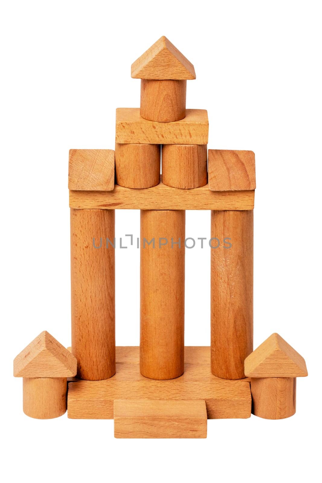 Wooden house isolated. Wooden toy castle constructed of cubes, cylinders, triangles and other shapes made of beech wood. Clipping path. Wooden toy blocks. Macro.