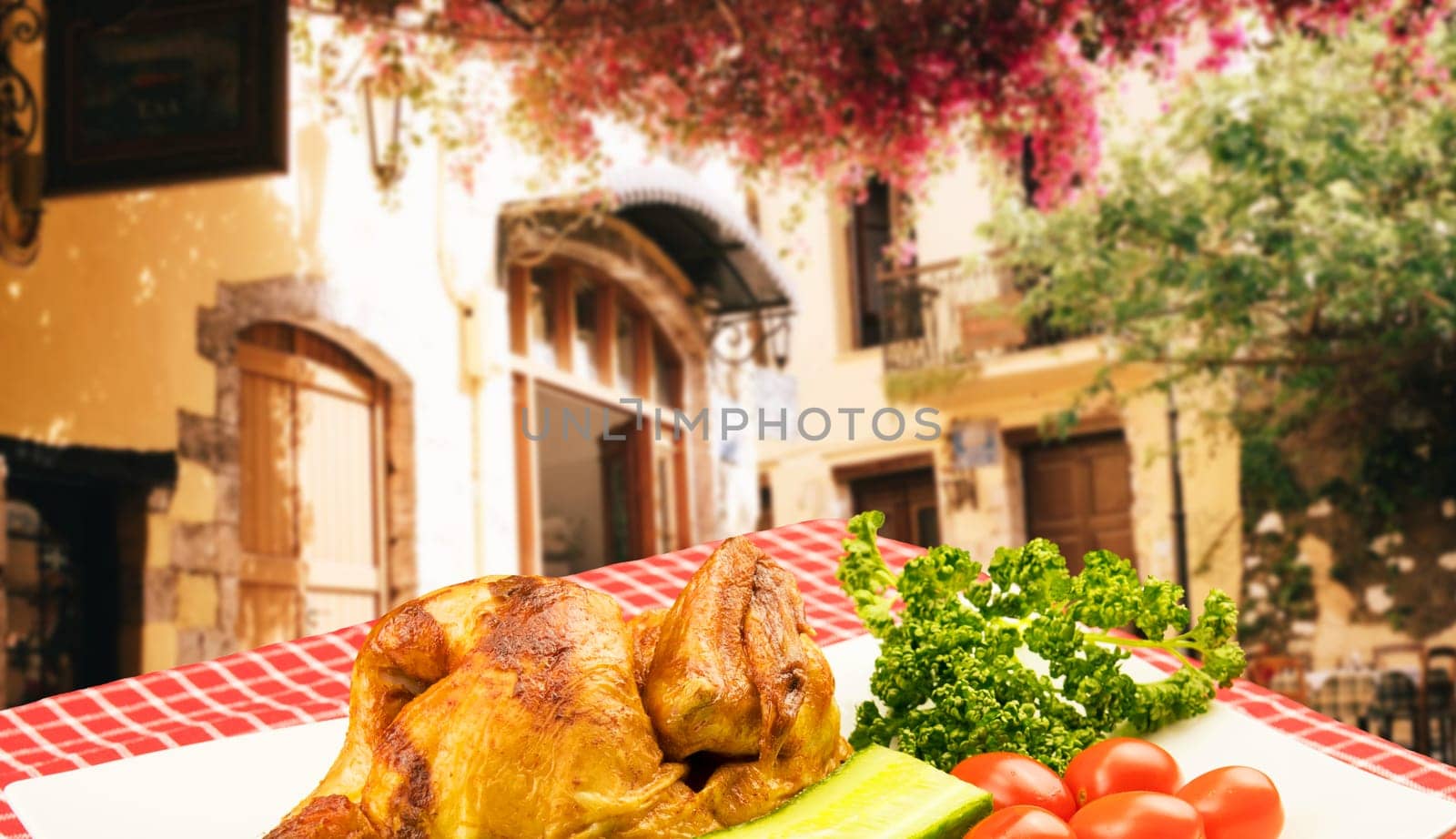 Grilled fresh fried chicken with vegetables on a white plate on table with red checkered table cloth over a blurred restaurant background. Meat on barbecue grill.