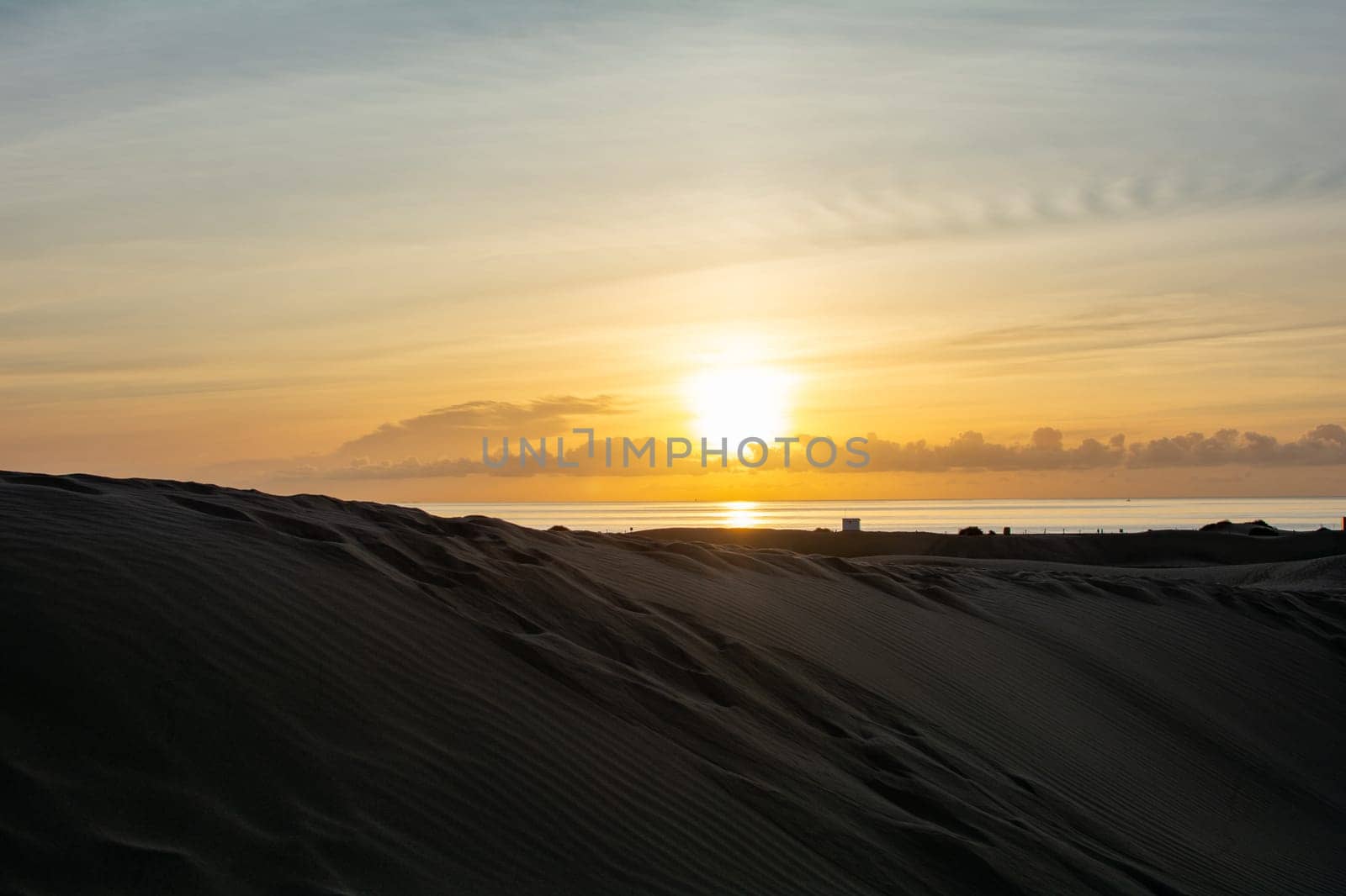 In the dunes of Maspalomas at sunrise on Gran Canaria in Spain. The huge sand dunes resemble a small desert and are a nature reserve.
