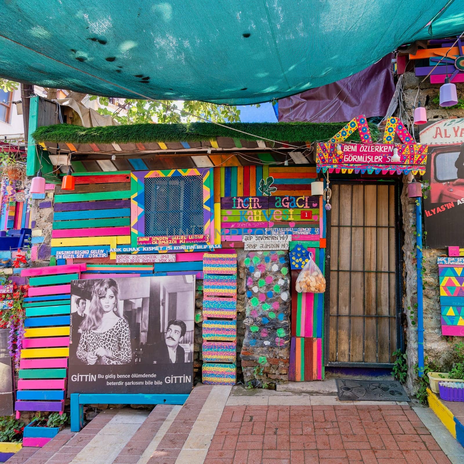 Exterior daytime shot of traditional cafe decorated with multicolored panels, movie posters and canopy in Balat District, Istanbul, Turkey