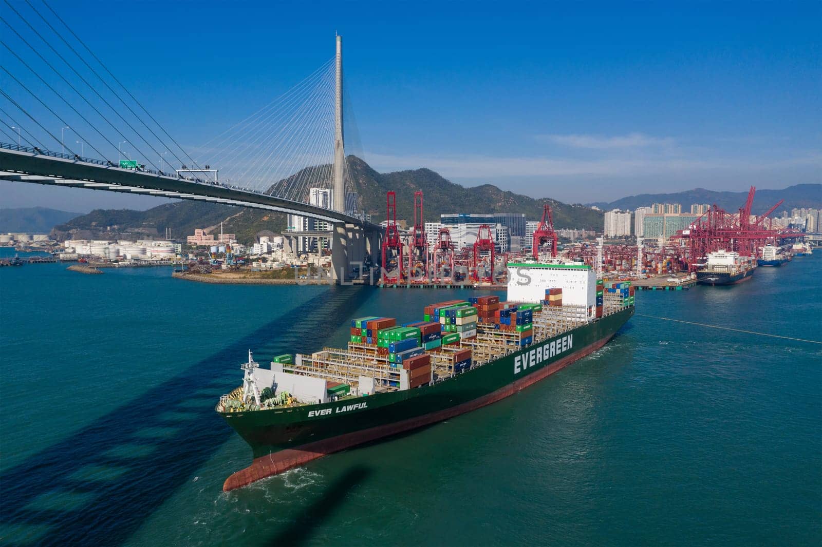 Kwai Tsing, Hong Kong 04 December 2019: Top view of cargo ship pass though suspension bridge