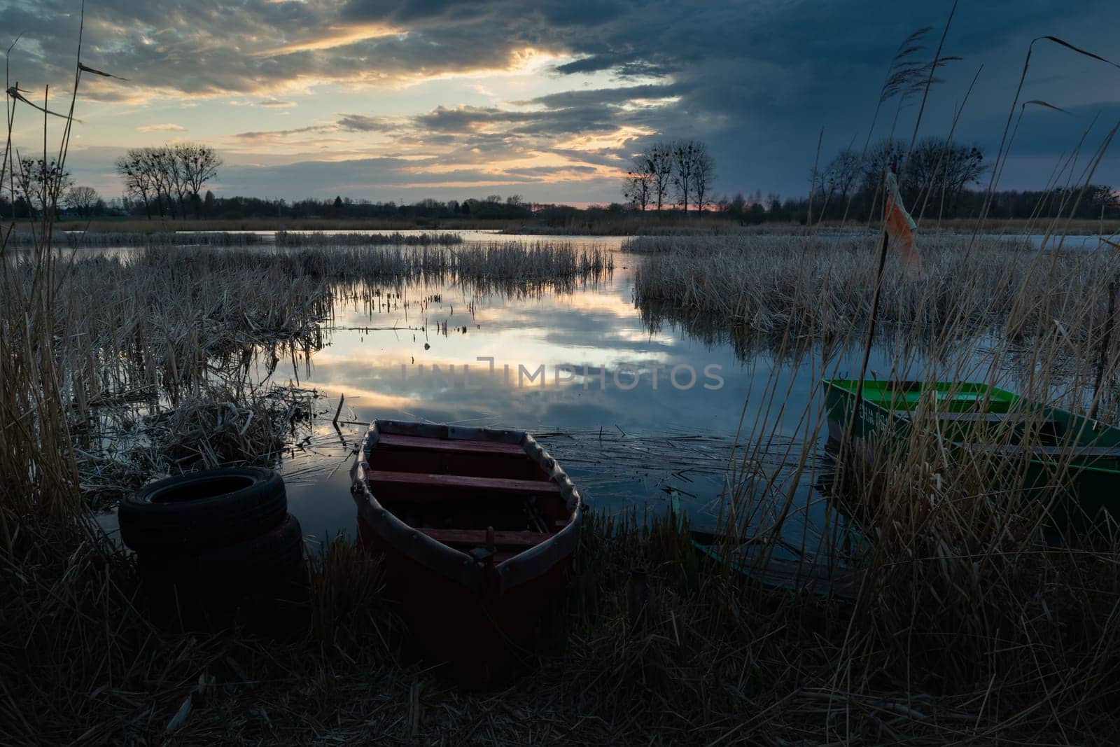 Smal boats on the shore of the lake on a cloudy evening