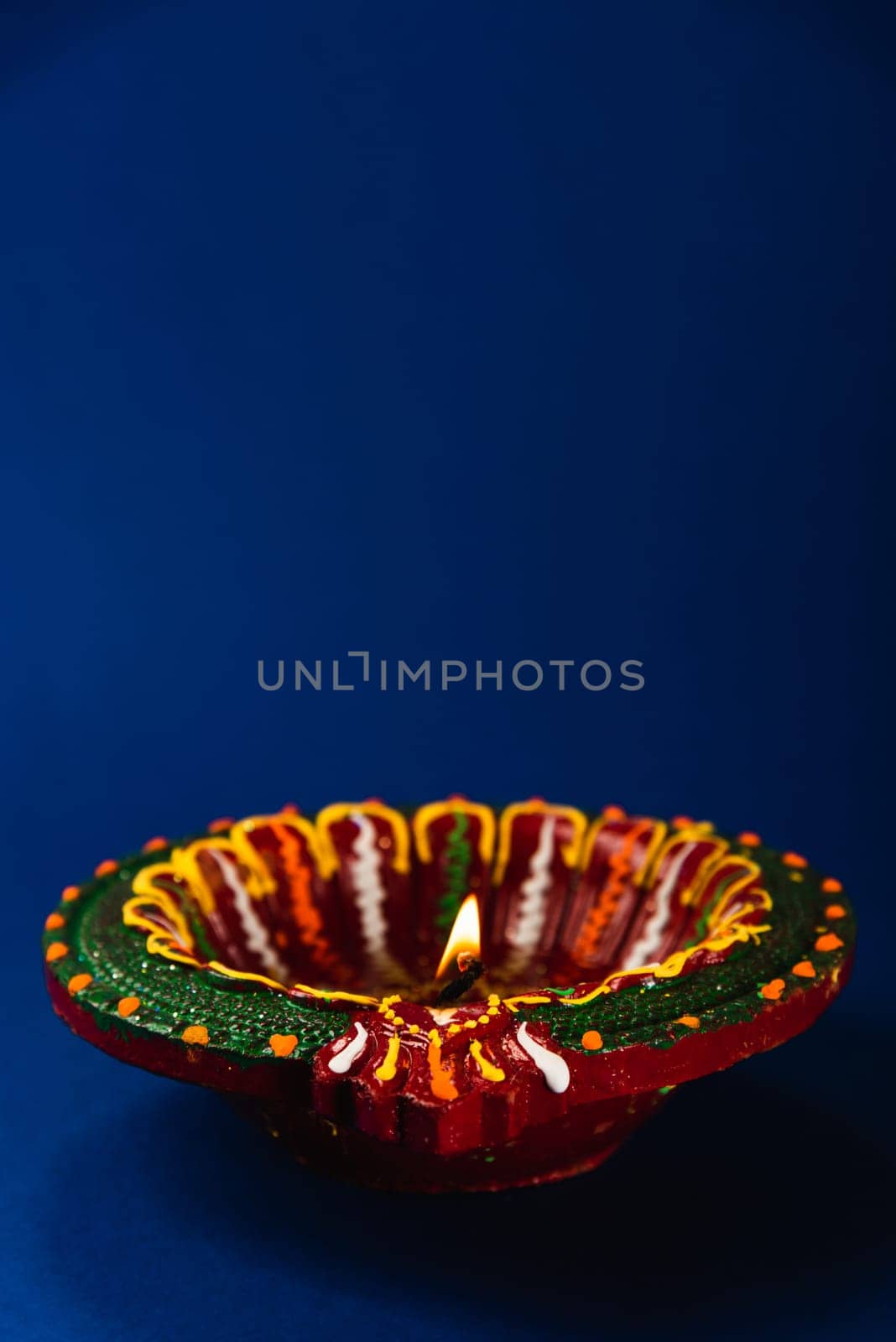 Celebrate Diwali with these shining clay diya lamps, symbols of prosperity and happiness, radiating warmth on a blue background. Perfect for invitations, religious-themed art, and text overlays.
