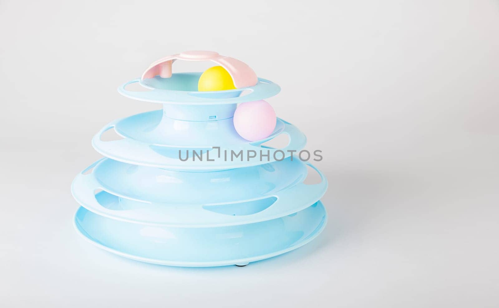 The white backdrop highlights a blue cat tower toy, circular turntable, and a cat's paw gripping a moving ball. It's all about feline intelligence and hunter instincts during playtime.