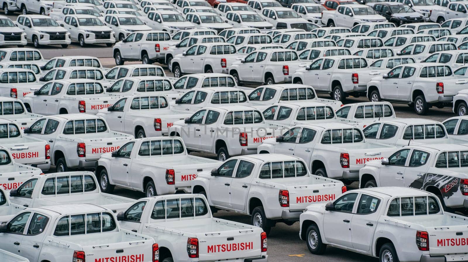 Lamchabang, Thailand - July 02, 2023 On a cloudy day at the car factory, new cars occupy rows in the distribution center. top view showcases the bustling parkinga testament to modern manufacturing.