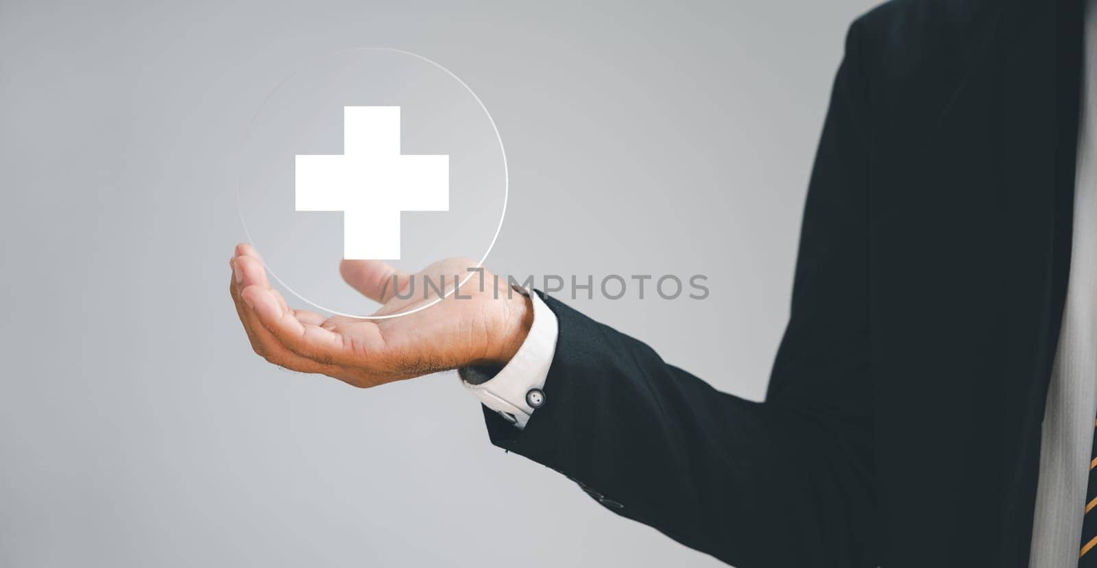 Hand holds a plus sign, representing positivity, benefits, personal development, health insurance. Conveys value enhancement within a corporate framework. Offers a motivating growth perspective.