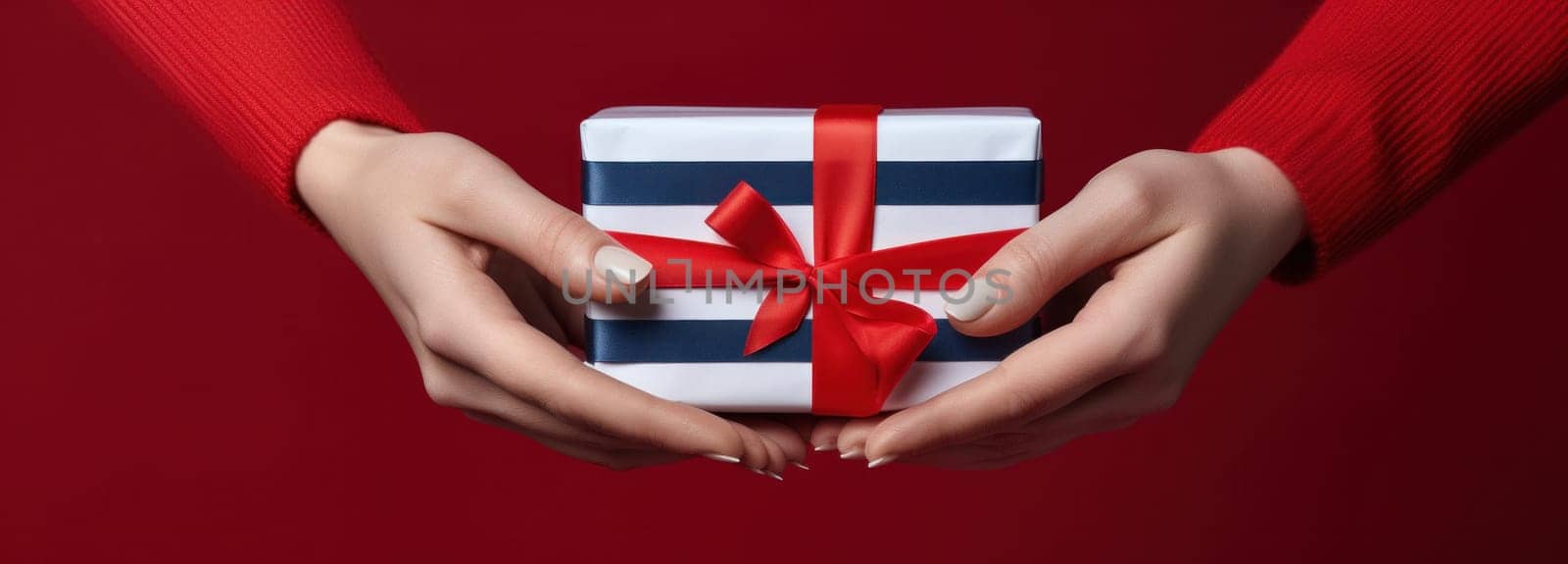 christmas gift wrapping package with striped ribbon by lady hands.
