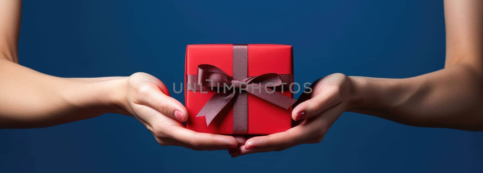 woman opens present in red hand holding gift box.