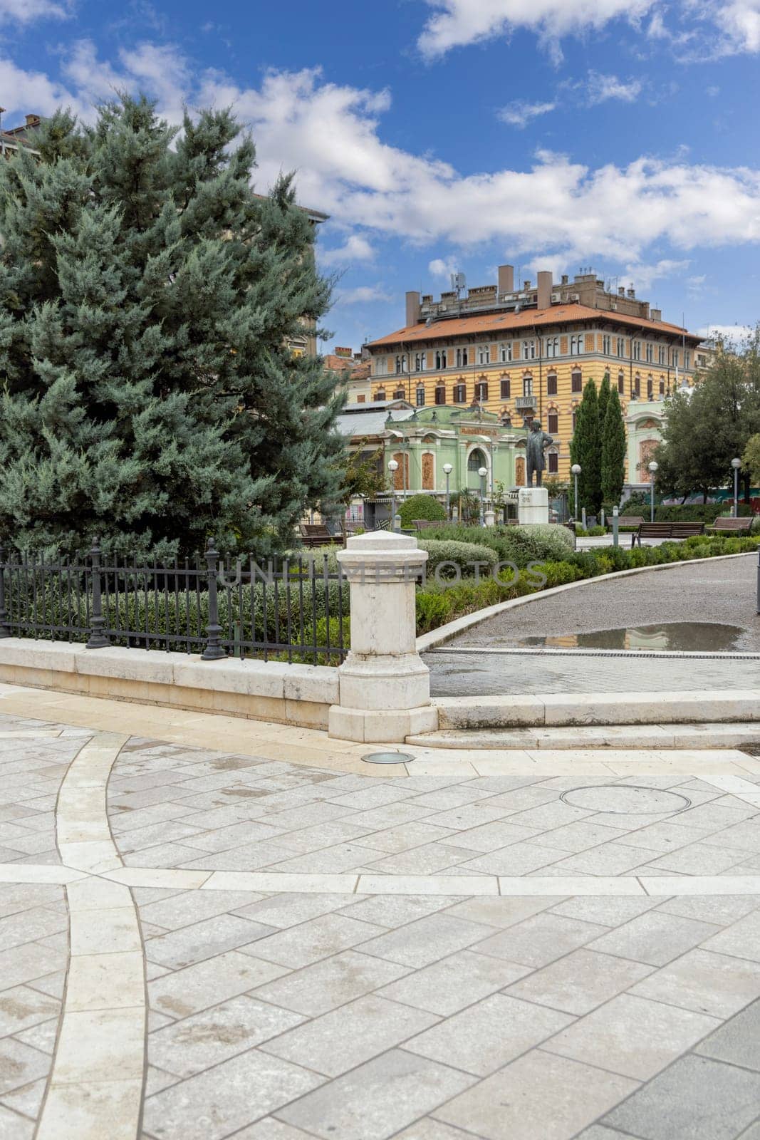 Rijeka, Croatia - September 23, 2023: Classicist-art nouveau style Theatre Park with statue of Ivan Zajc, Croatian composer. Great Market Hall in the distance
