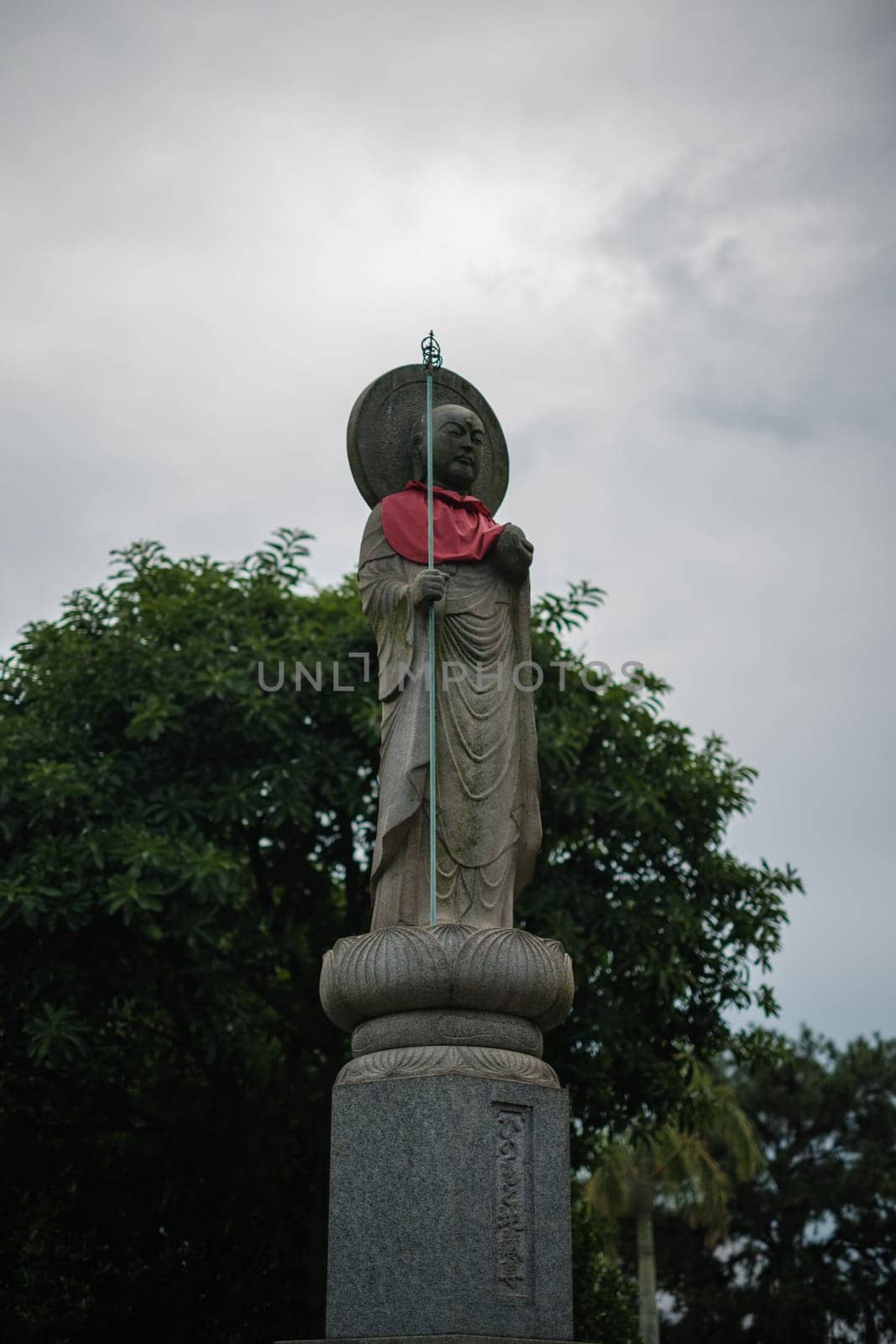 Singapore - July 9 2023: Stone Monk Statue With Red Scarf