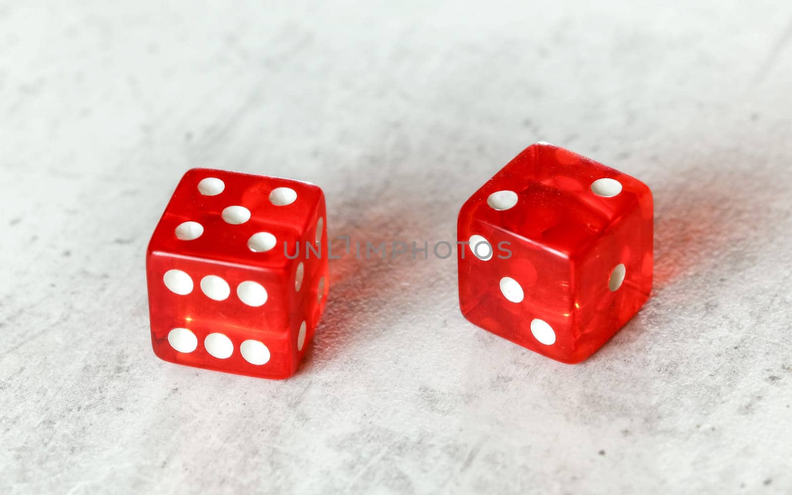 Two translucent red craps dices on white board showing Natural or Seven Out (number 5 and 2)