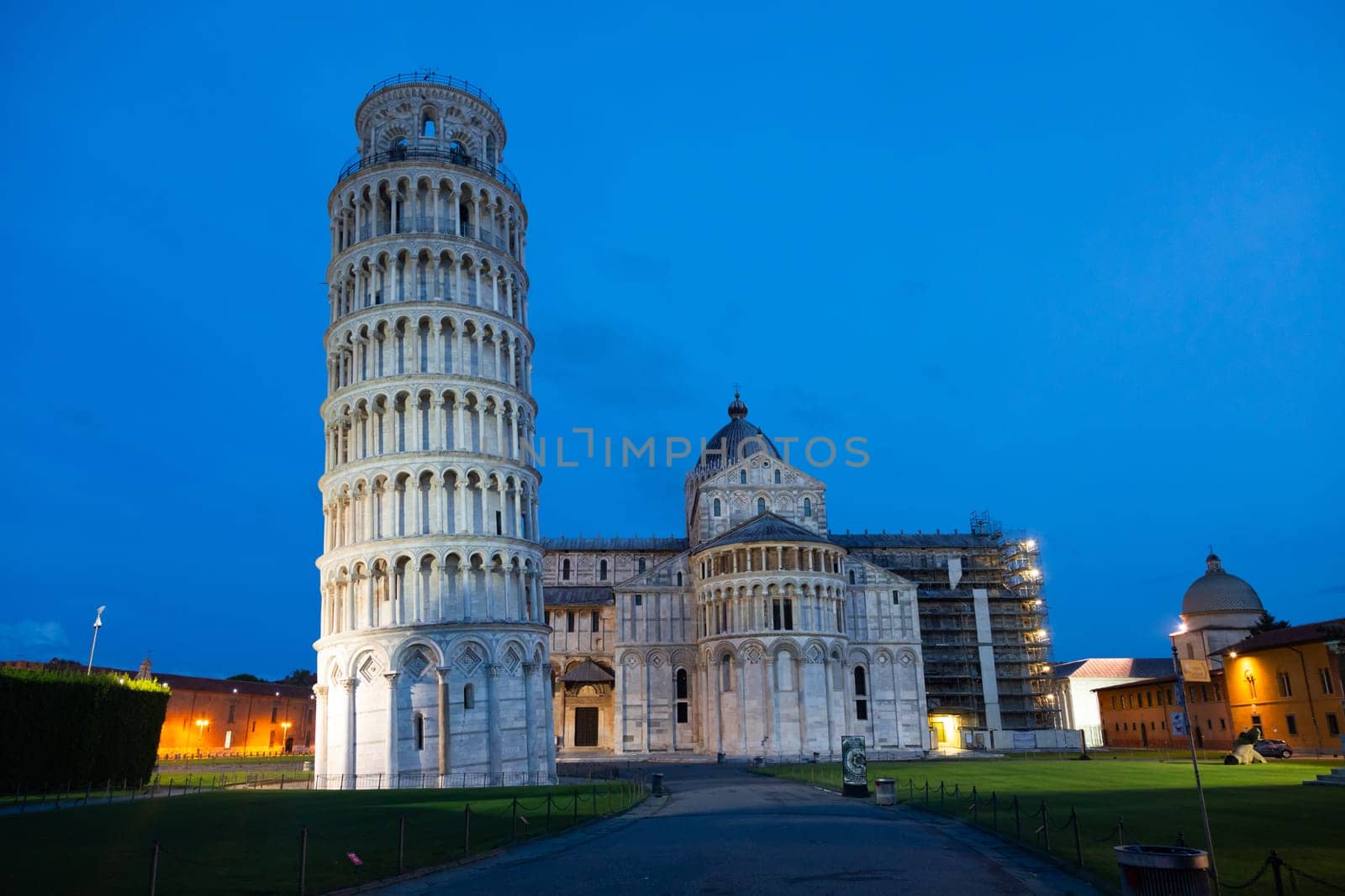 Pisa, Italy - 01 July 2023: leaning tower and cathedral panorama by night, blue sky