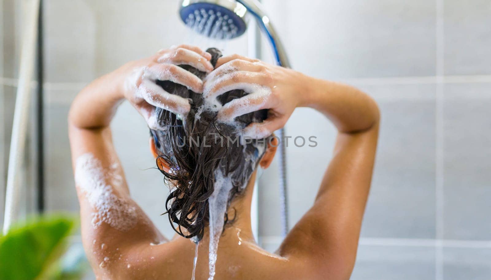 Woman washing his hair in the shower, close-up, rear view. AI generated