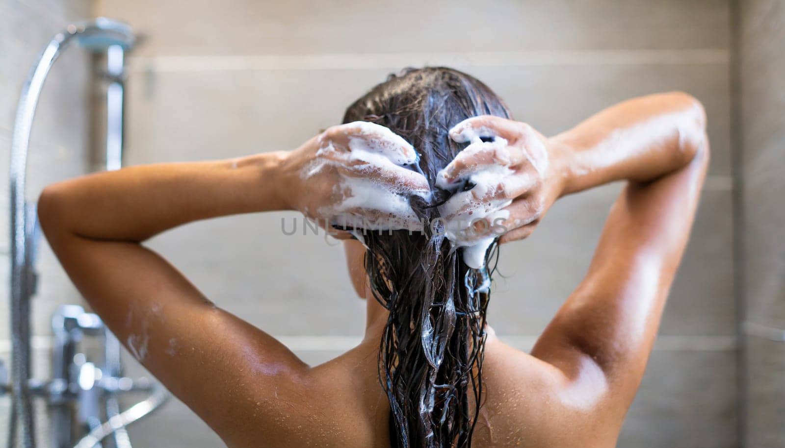 Woman washing his hair in the shower, close-up, rear view. AI generated