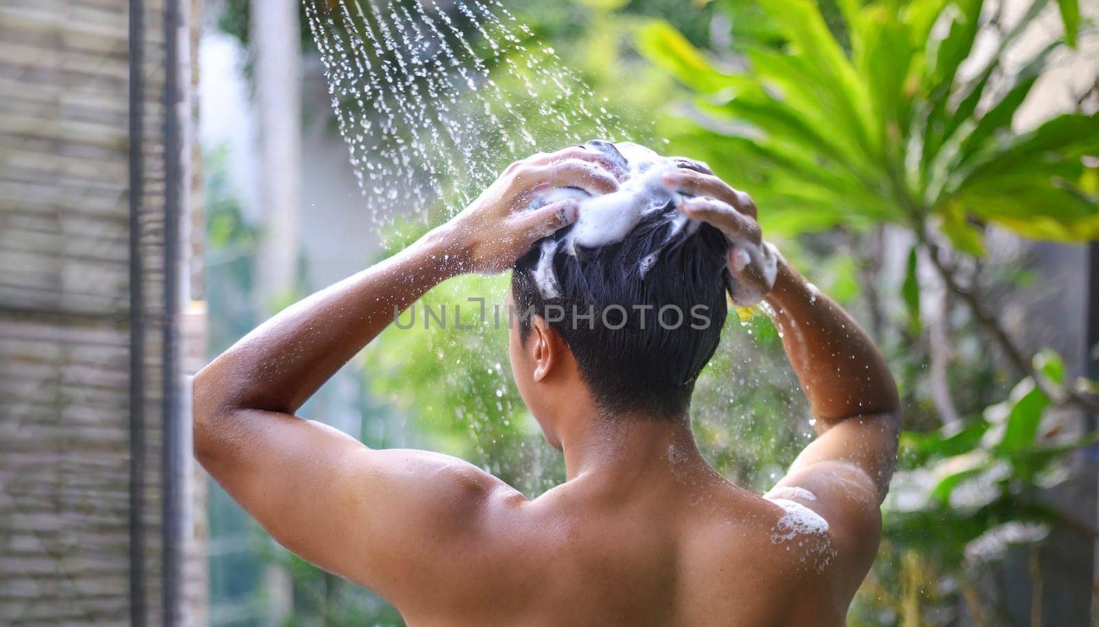 Man washing his hair in the shower, close-up, rear view. AI generated