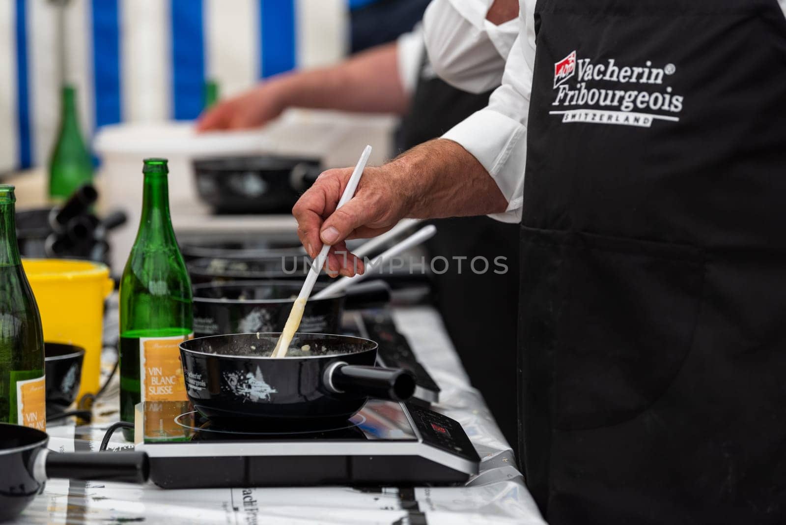 September 28 2019, Charmey, Fribourg, Gruyeres, Switzerland : men are cooking the half-and-half fondue caquelons in Charmey accompanied by Swiss white wine during the transhumance festival