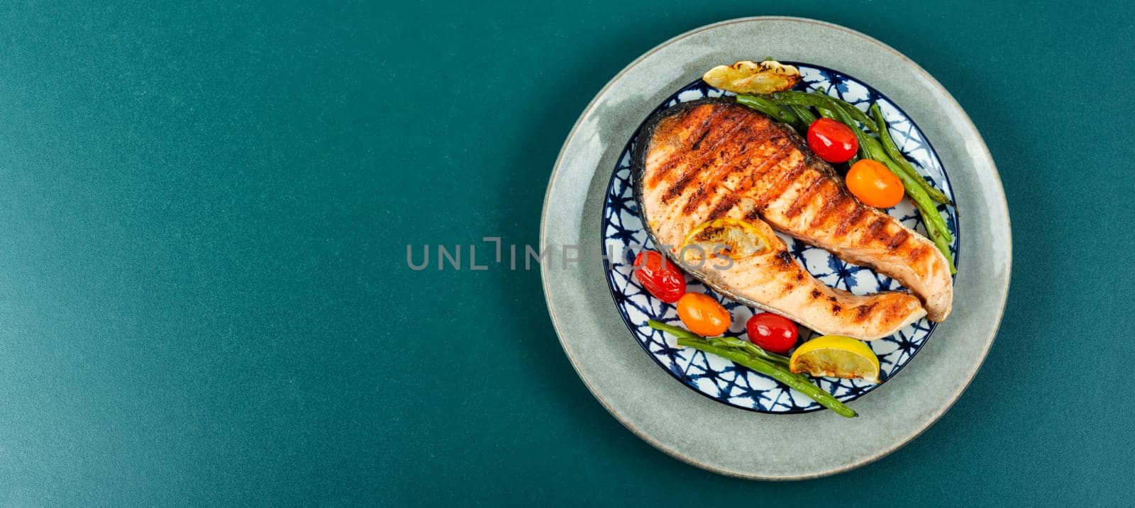 Grilled salmon steak with grilled vegetables, fried fish. Flat lay with copy space.