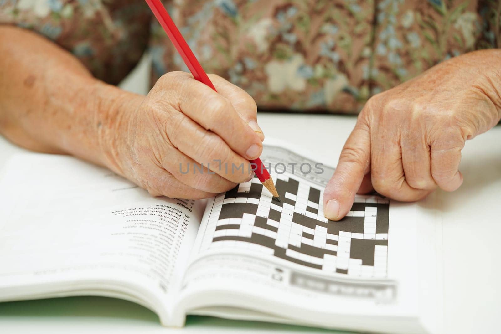 elderly woman playing sudoku puzzle game for treatment dementia prevention and Alzheimer disease.