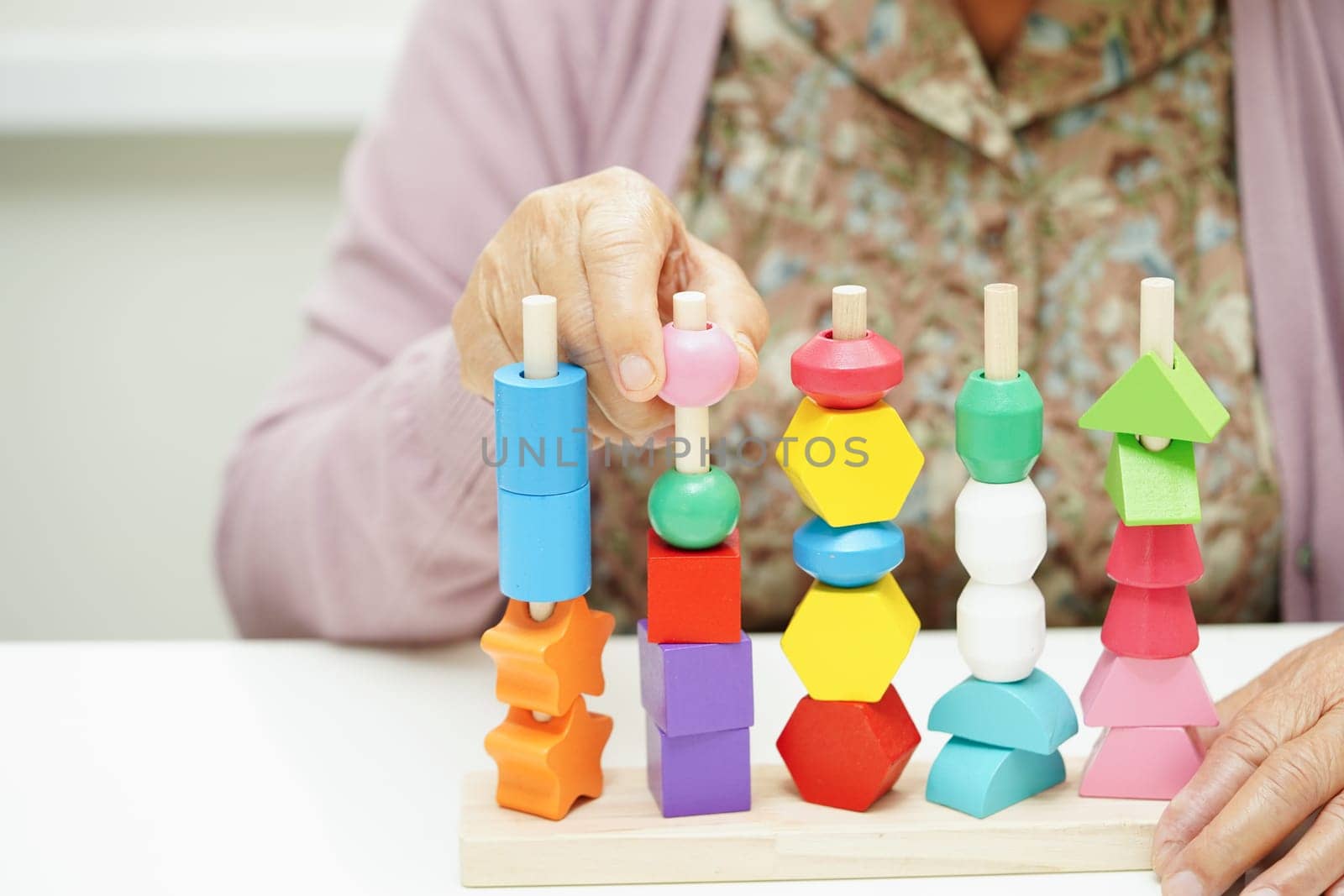 Asian elderly woman playing puzzles game for treatment dementia prevention and Alzheimer disease.