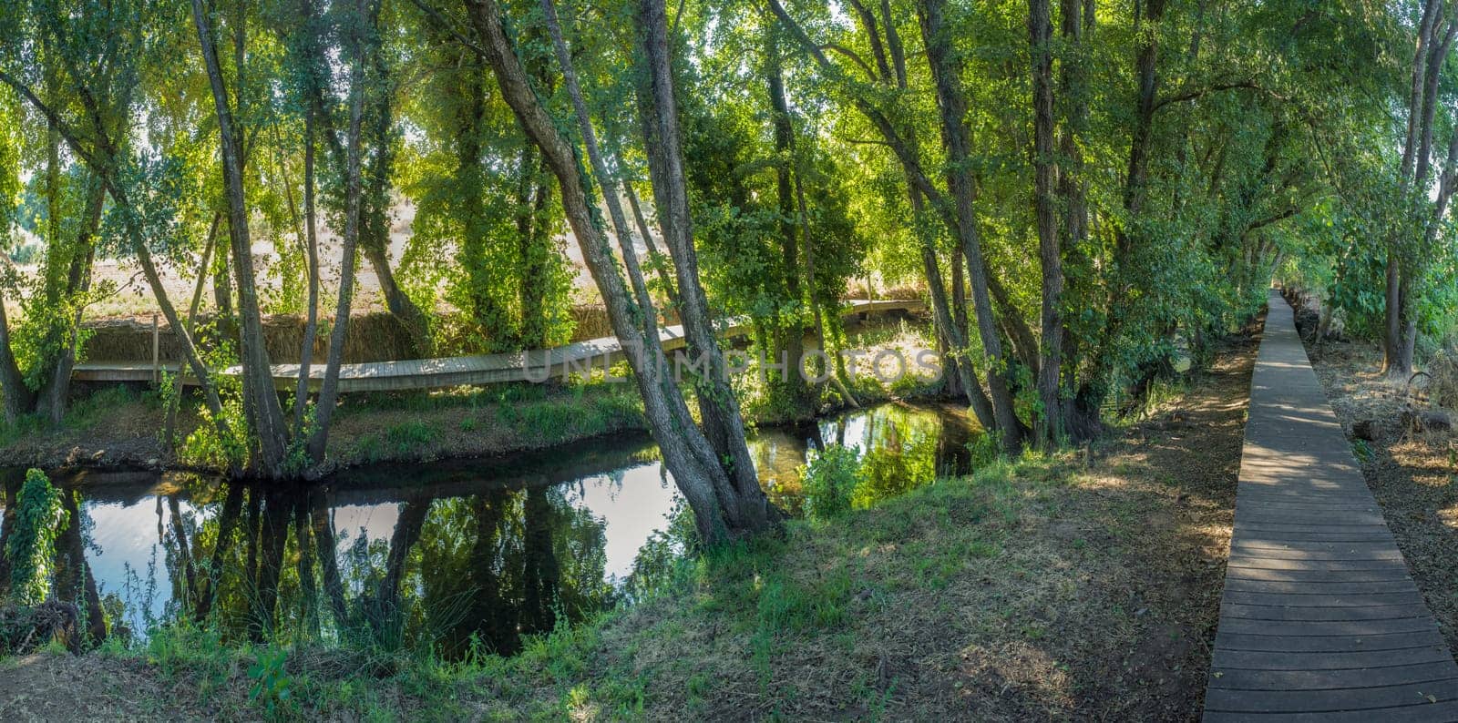 Footbridge along Gevora river, La Codosera, Badajoz, Extremadura, Spain. Idyllic location of crystal clear waters and riverside forests