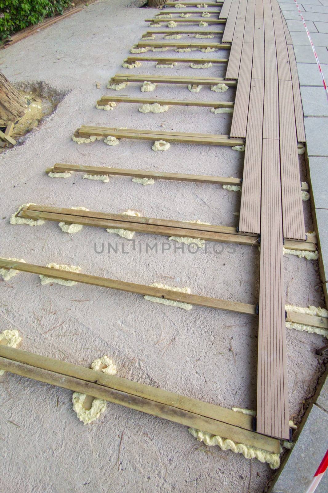 Installation of wooden flooring on a polyurethane foam base. Urban background close to public park