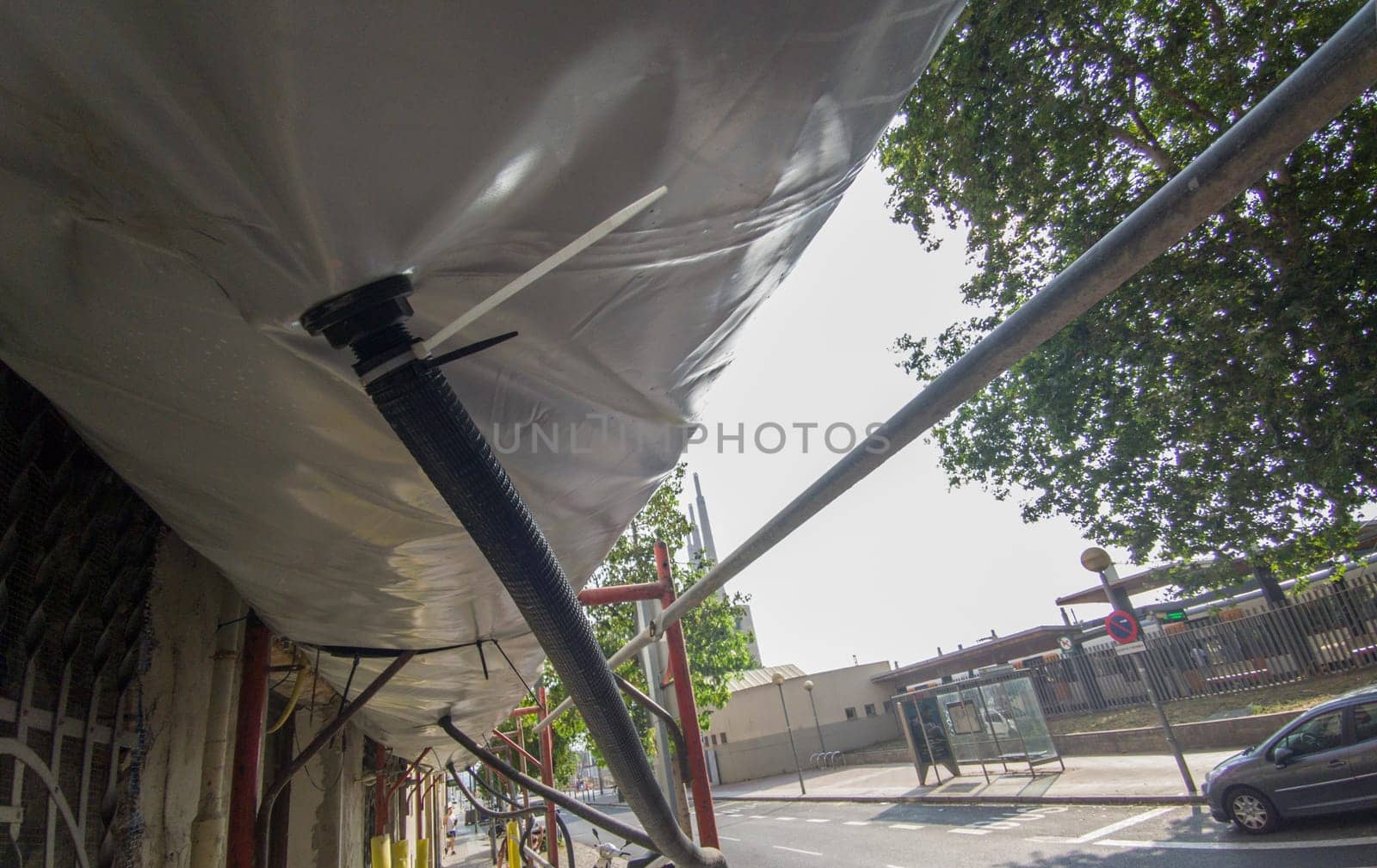 Scaffold equipped with pedestrian protection devices. Dust collection tubes. Ground level