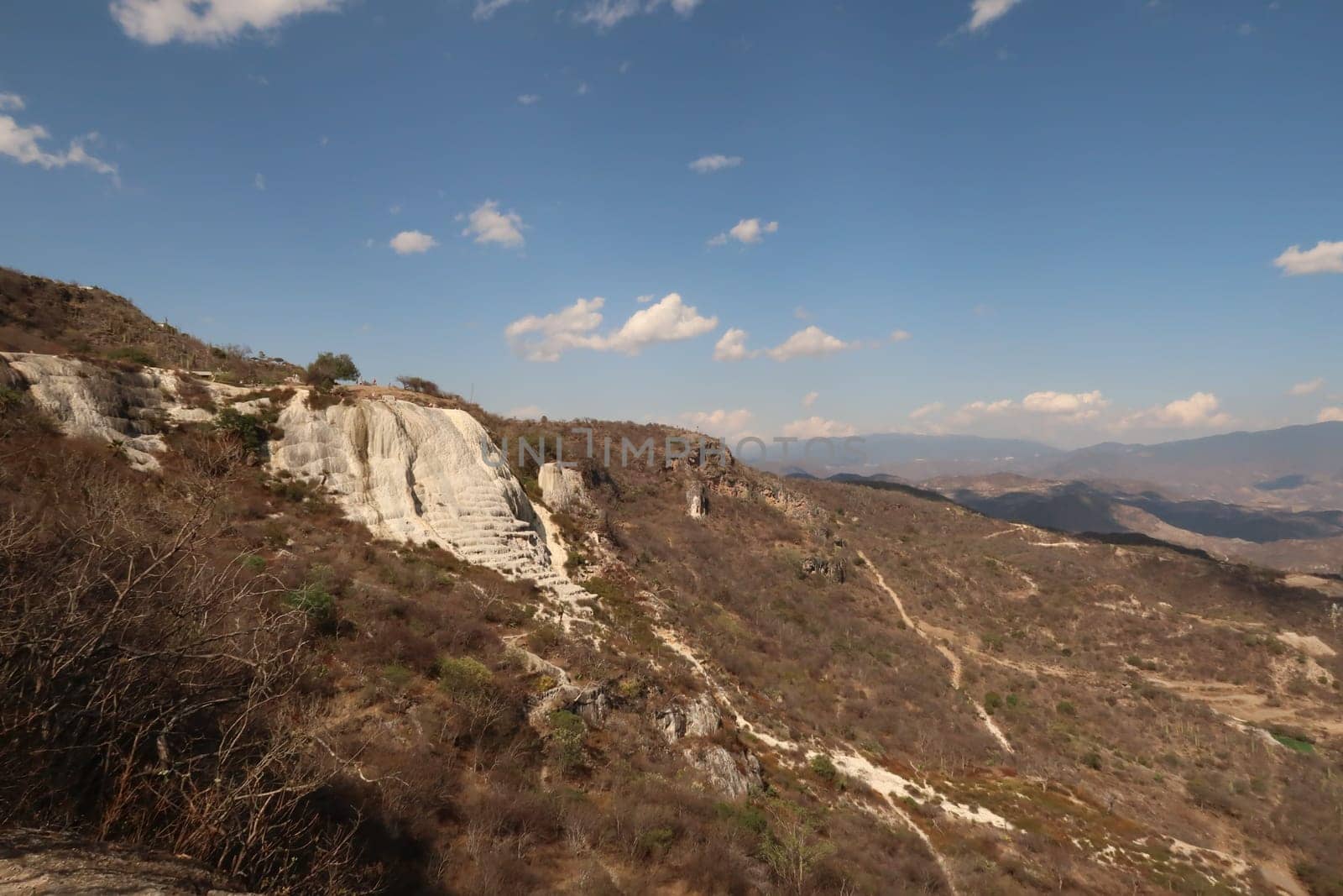 Seeing the travertine rock formations and pools of Hierve El Agua between the Oaxacan landscape from a distance, Mexico 2022
