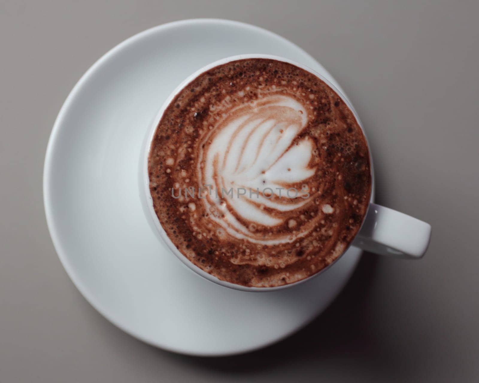 A cup of coffee decorated with a palm symbol and sprinkled with chocolate powder