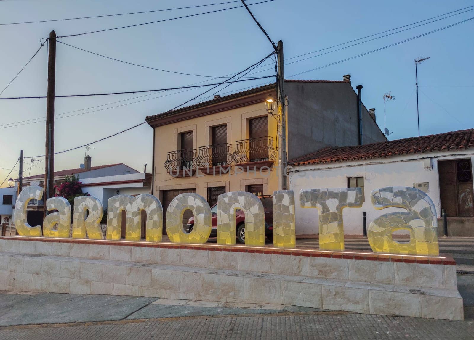 Carmonita, Spain - Agust 14th, 2022: Sign letters of Carmonita, Badajoz, Extremadura, Spain. Little town identifying sign at dusk