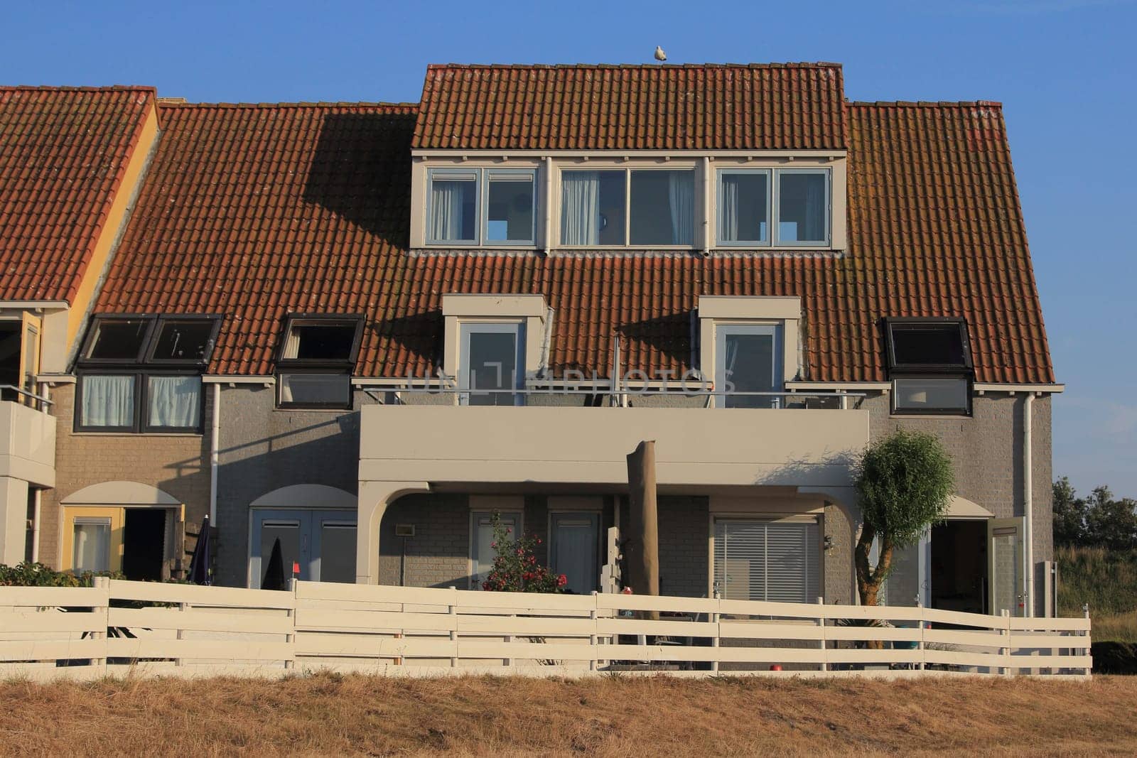 A little beige house with blue sky in the background