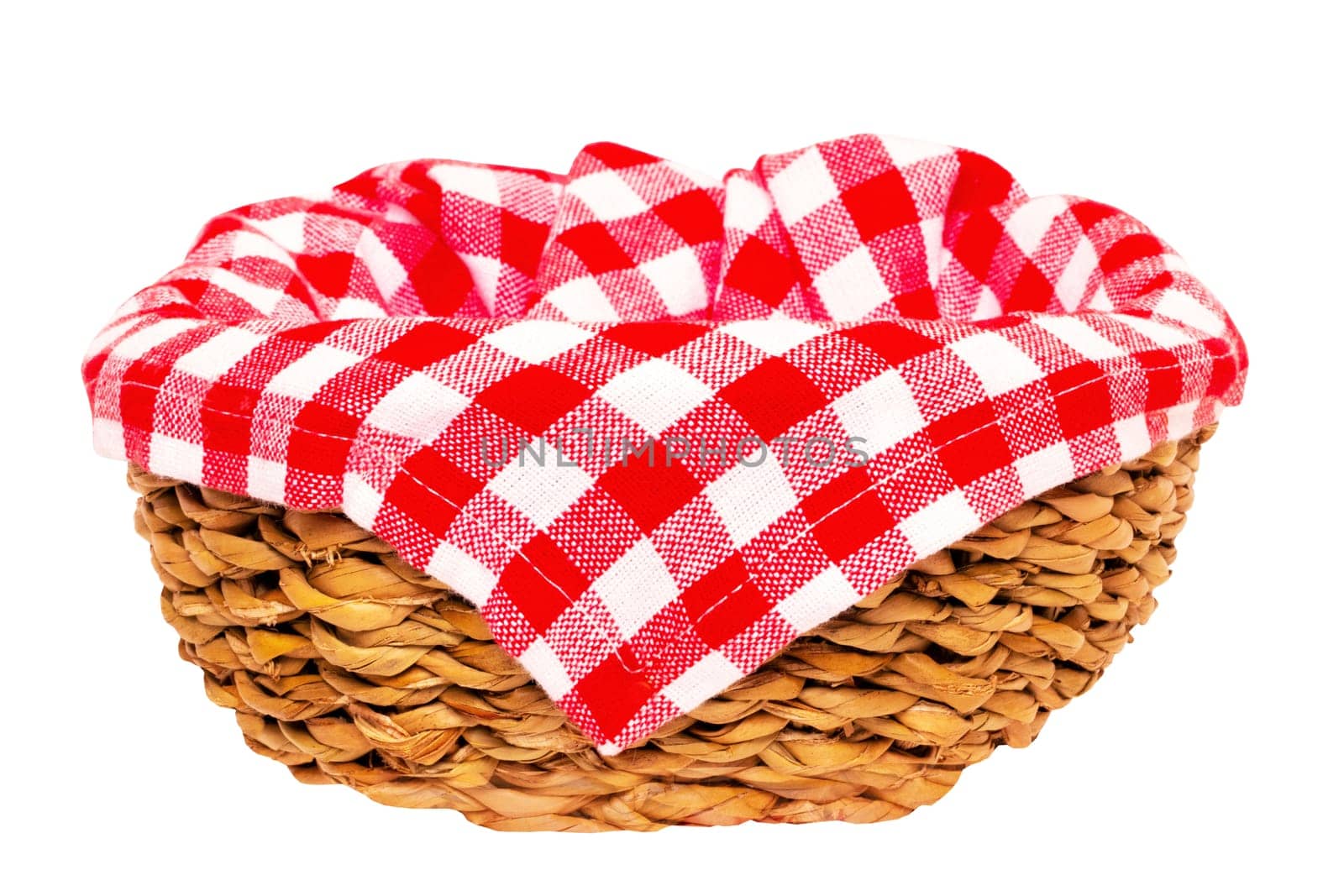 Empty picnic basket. Close-up of a empty straw basket therein a red checkered napkin isolated on a white background. For your food and product display montage. Macro.