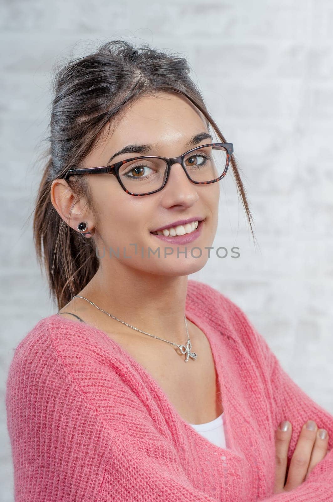 young smiling brunette woman with a pink sweater