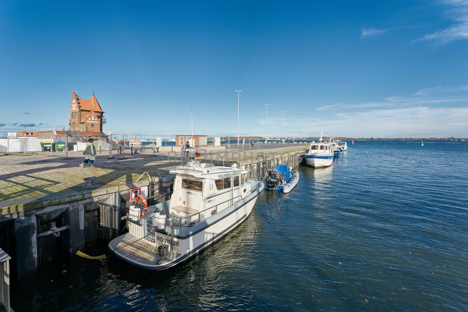 Boat of the fishing inspectorate in the port of Stralsund. The historic pilot house in the background