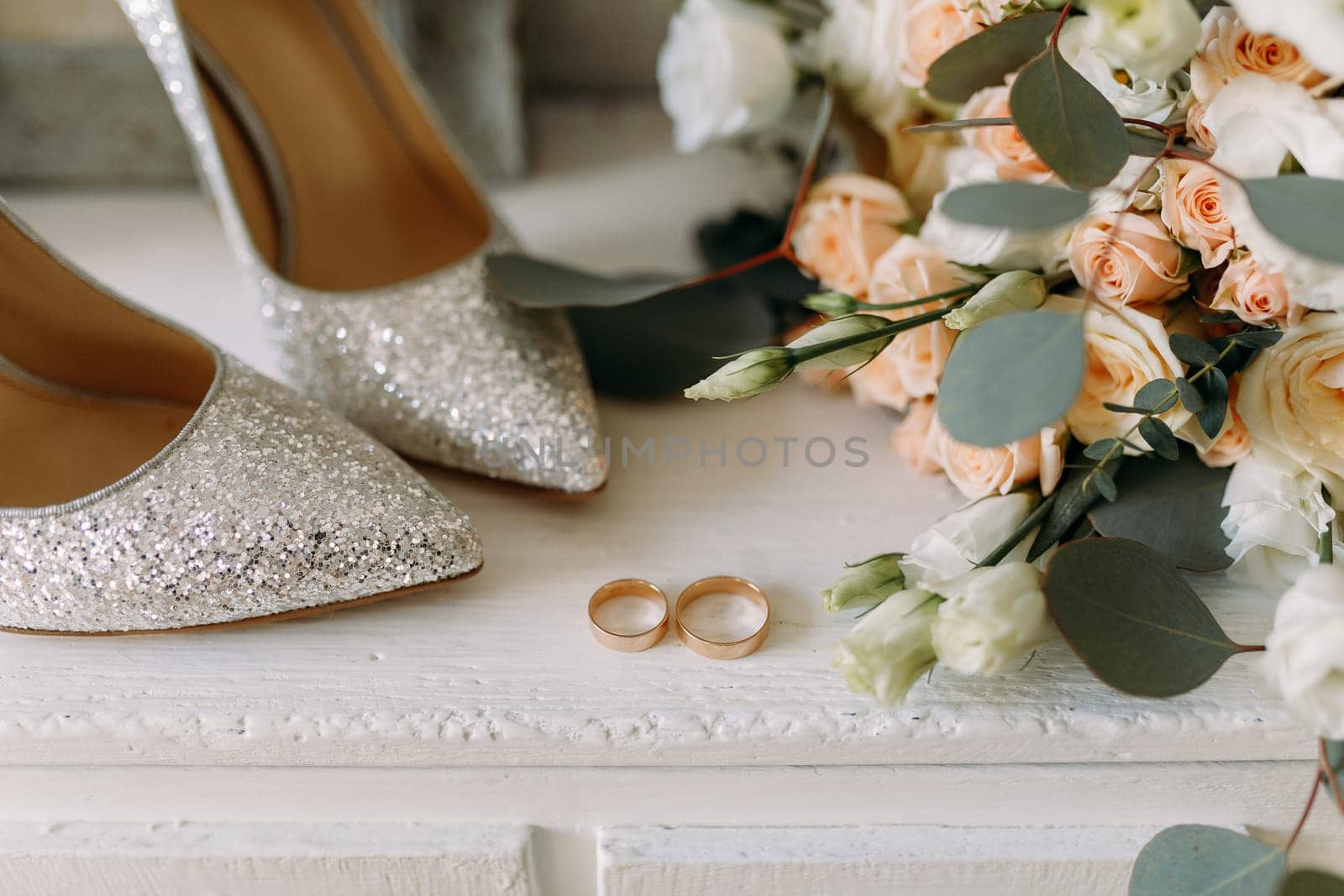 Wedding shiny shoes and wedding paraphernalia, gold wedding rings, wedding bouquet.View from above