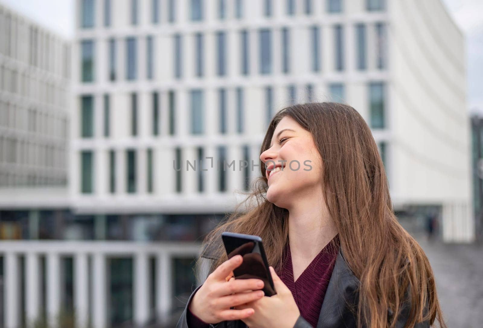happy young woman with smartphone in the city