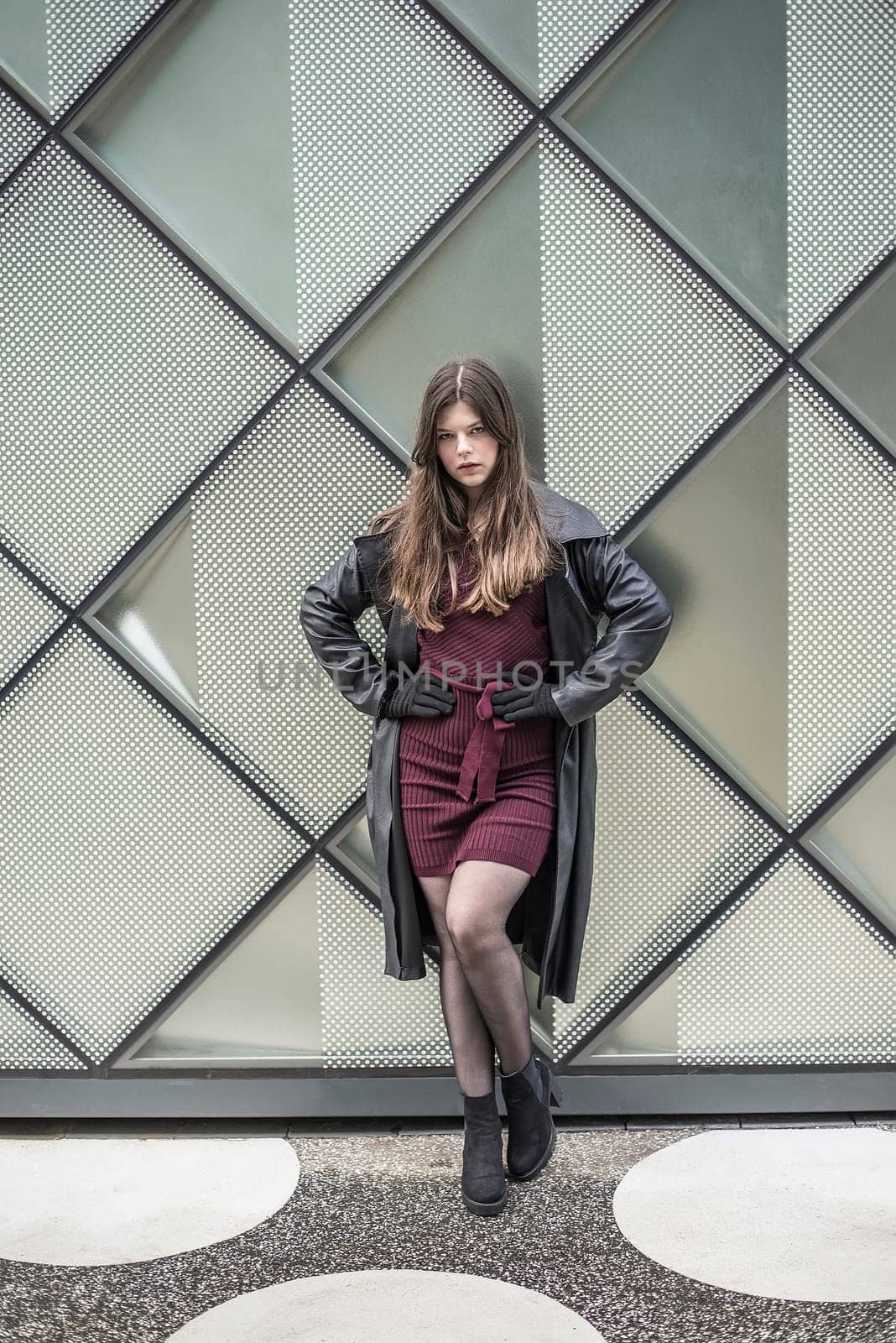 confident young woman with long black coat in the city