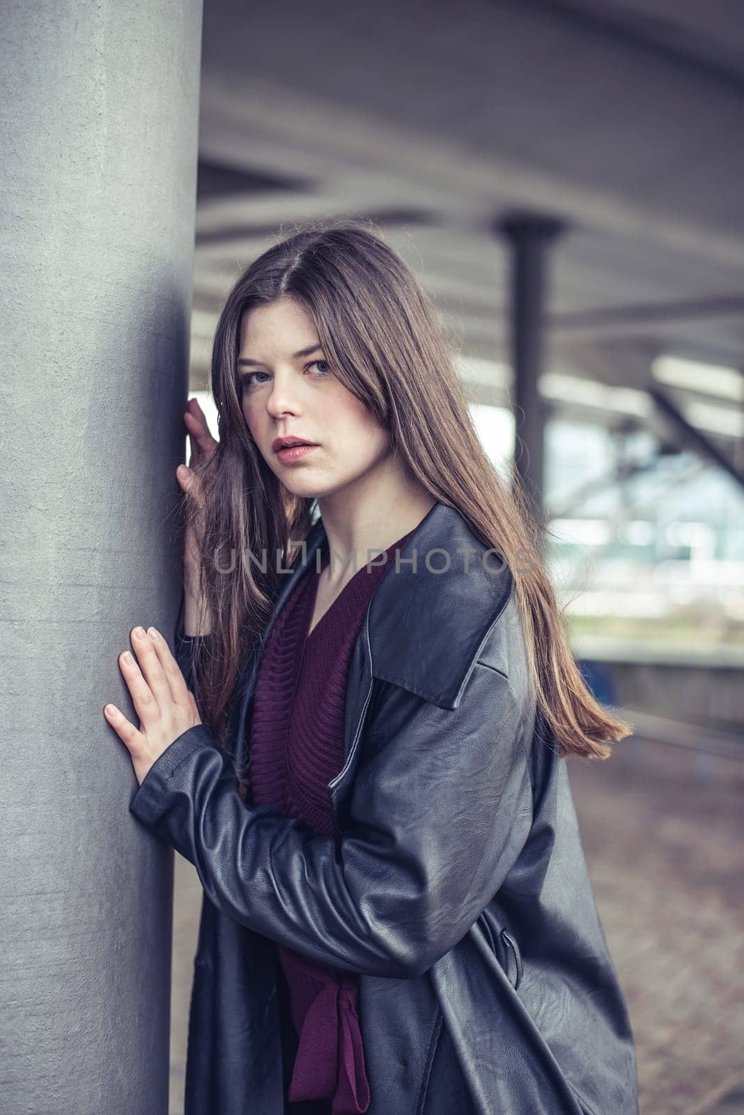 confident young woman with long black coat in the city