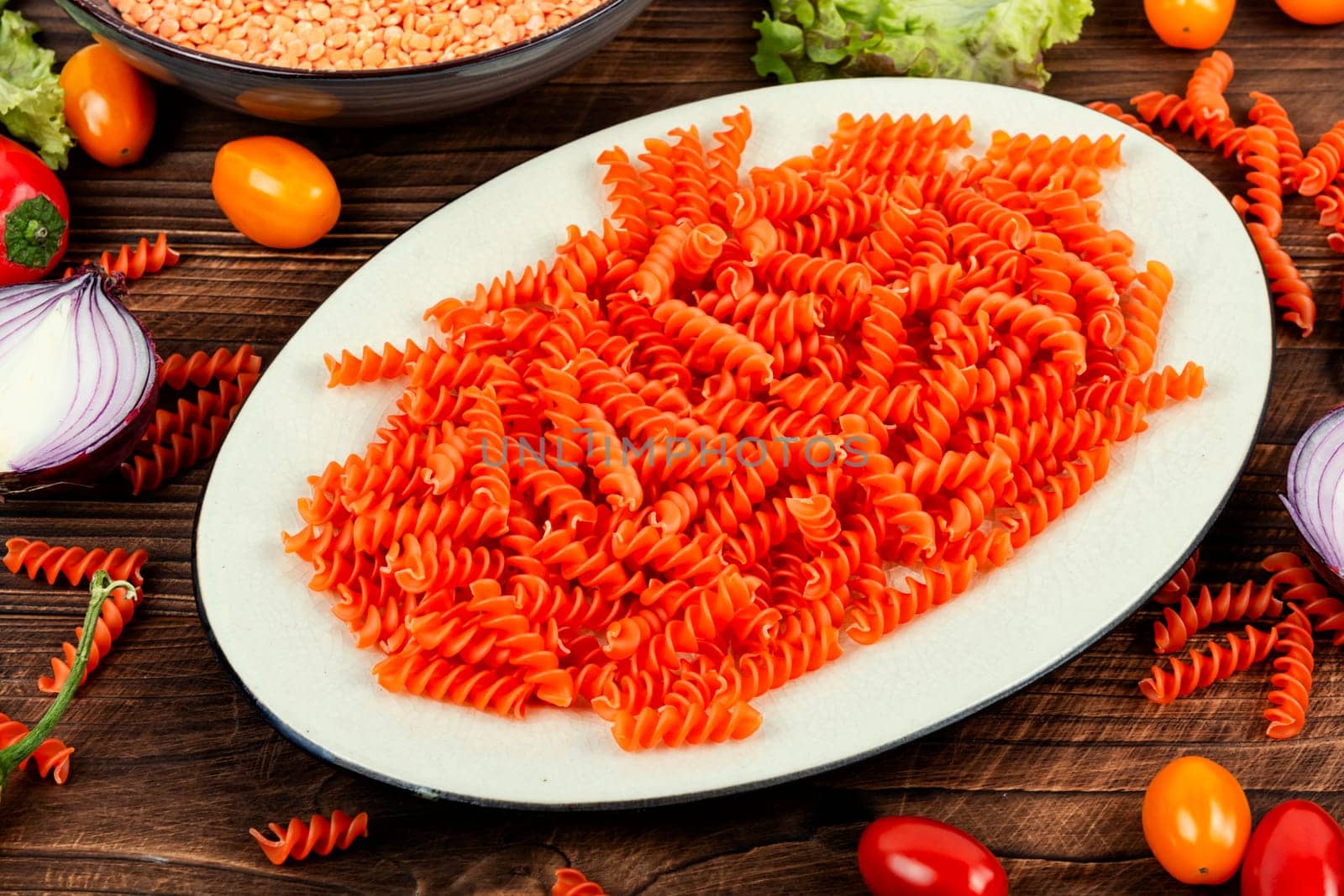 Dry red lentil fusilli pasta. Uncooked vegan pasta. Italy cuisine. Space for text.