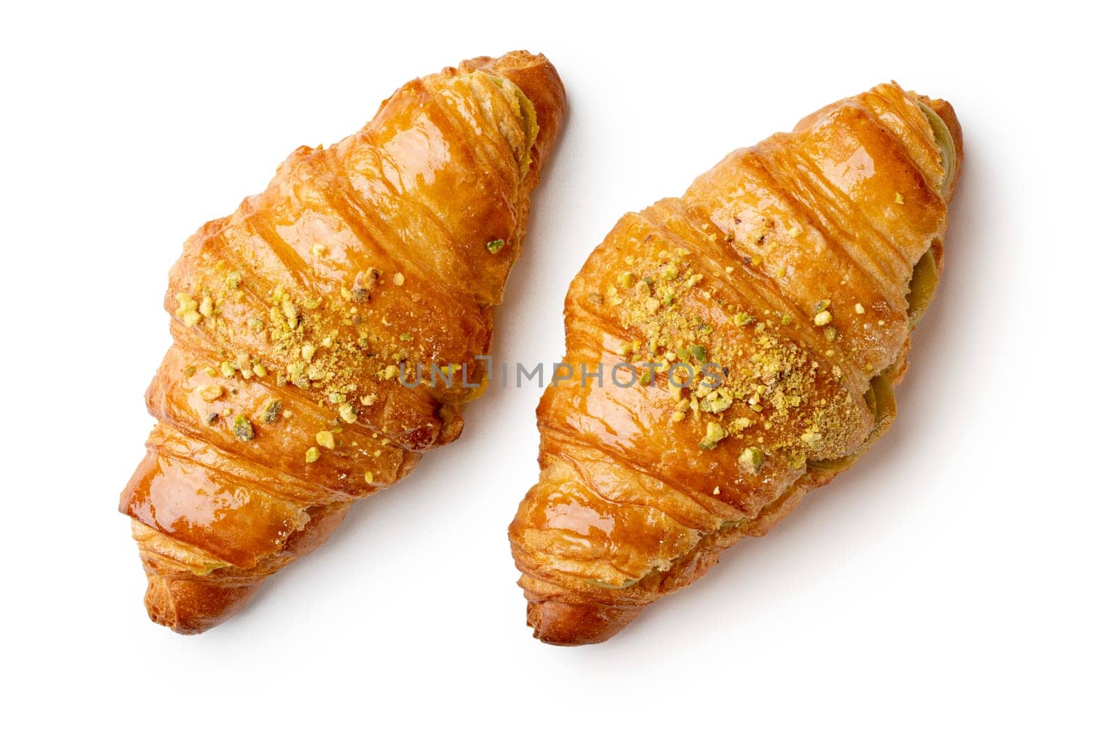 Indulge in flaky perfection with two pistachio cream croissants. the buttery layers and nutty filling create an irresistible, gourmet treat. ideal for showcasing french pastry artistry, this image captures the essence of quality, freshness, and indulgence